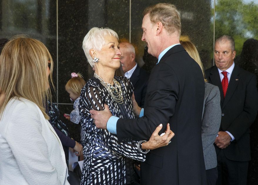 Joan "Jody" Dixon, the wife of former U.S. Sen. Alan J. Dixon, greets her son Jeffrey Dixon, after he spoke at a dedication ceremony to name the building that houses the Illinois State Museum after his father, Wednesday, May 13, 2015 in Springfield, Ill. The building is now called the Alan J. Dixon Building. During the ceremony, House Speaker Michael Madigan said Dixon "was just about helping people, helping working people get ahead." (Ted Schurter/The State Journal Register via AP) MANDATORY CREDIT, NO SALES