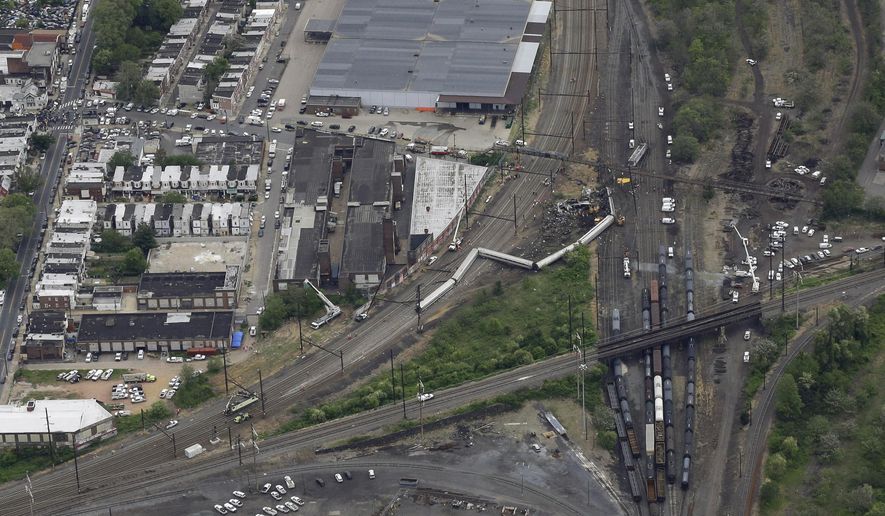 In this aerial photo, emergency personnel work at the scene of a deadly train wreck, Wednesday, May 13, 2015, in Philadelphia. Federal investigators arrived Wednesday to determine why an Amtrak train jumped the tracks in the wreck, Another body has been pulled from the wreckage of an Amtrak train derailment in Philadelphia, increasing the death toll to at least seven. (AP Photo/Patrick Semansky)