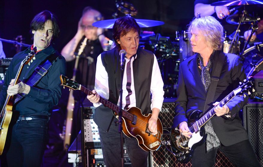 FILE - In this Feb. 14, 2015 file photo, Paul McCartney, center, and his band, including Rusty Anderson, left, and Brian Ray, perform a secret Valentine's Day concert at Irving Plaza in New York. McCartney played a private concert with a crowd that included Wall Street executives and boldface names that included Sting and Oprah. The concert on Tuesday night, May 12, 2015, was part of the Robin Hood Foundation's annual benefit. Founded in 1988, the organization has raised more than $2 billion to combat poverty in New York's five boroughs. (Photo by Evan Agostini/Invision/AP, File)