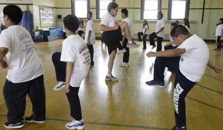 In this May 26, 2009, file photo, Betty Hale, center, instructs a physical education class at Eberhart Elementary School in Chicago. (AP Photo/M. Spencer Green, File)