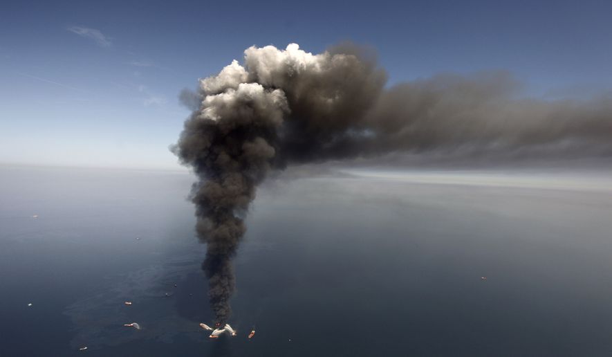 Oil can be seen in the Gulf of Mexico, more than 50 miles southeast of Venice on Louisiana&#39;s tip, as a large plume of smoke rises from fires on BP&#39;s Deepwater Horizon offshore oil rig in this April 2010 file photo. (AP Photo/Gerald Herbert, File)