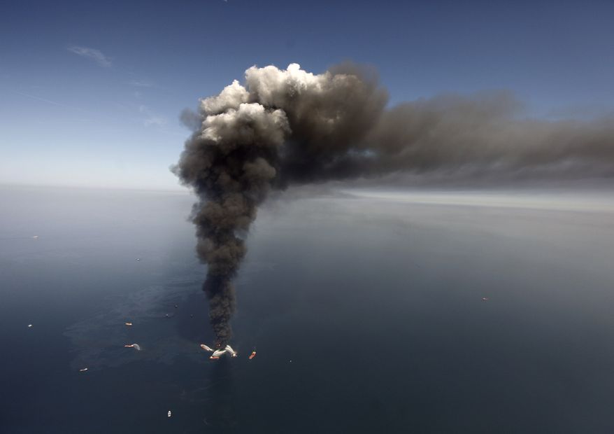 Oil can be seen in the Gulf of Mexico, more than 50 miles southeast of Venice on Louisiana&#39;s tip, as a large plume of smoke rises from fires on BP&#39;s Deepwater Horizon offshore oil rig in this April 2010 file photo. (AP Photo/Gerald Herbert, File)