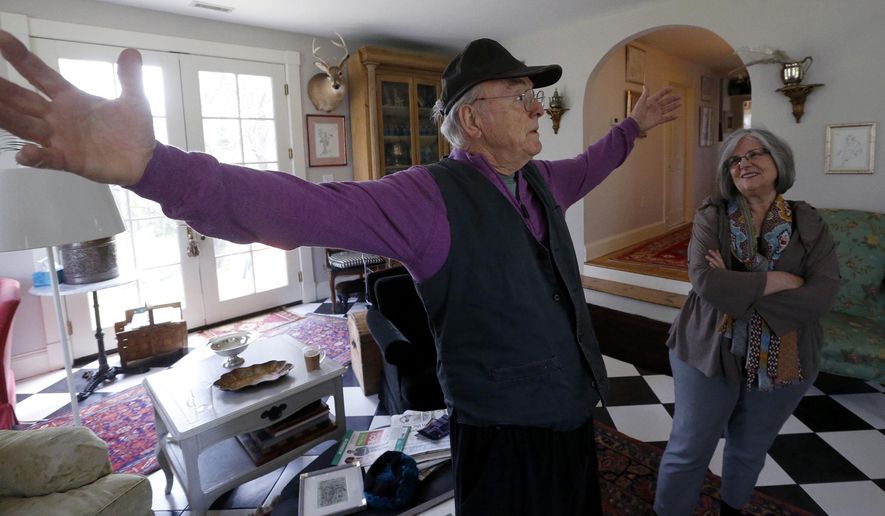 ADVANCE FOR USE SUNDAY, MAY 17 - In this photo taken March 30, 2015, Bill Kendrick, a longtime Richmond, Va., artist, gestures as talks with visitors to his home in Richmond, Va., as his wife, Debbie, right, looks on. Kendrick is still painting, ever reinventing himself as an artist, even as he approaches age 87. He has slowed a little recently, he admits, but that’s to be expected after you fall off a roof. (Bob Brown/Richmond Times-Dispatch via AP)