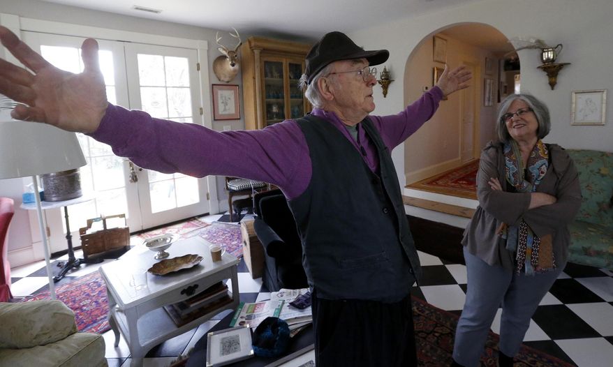 ADVANCE FOR USE SUNDAY, MAY 17 - In this photo taken March 30, 2015, Bill Kendrick, a longtime Richmond, Va., artist, gestures as talks with visitors to his home in Richmond, Va., as his wife, Debbie, right, looks on. Kendrick is still painting, ever reinventing himself as an artist, even as he approaches age 87. He has slowed a little recently, he admits, but that’s to be expected after you fall off a roof. (Bob Brown/Richmond Times-Dispatch via AP)
