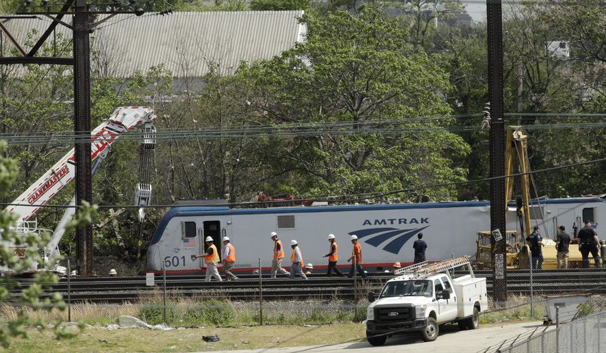 Emergency and transportation personnel work at the scene of a deadly train wreck, Wednesday, May 13, 2015, in Philadelphia. An Amtrak train headed to New York City derailed and crashed in Philadelphia on Tuesday night killing at least seven people and injuring dozens more. (AP Photo/Matt Slocum)