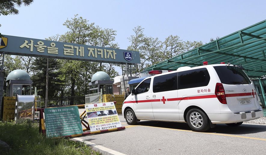 A military ambulance enters into a reserve forces training camp in Seoul, South Korea Wednesday, May 13, 2015. A South Korean reserve soldier went on a shooting spree Wednesday, killing a fellow reservist and injuring three others before killing himself, army officials said. The letters on the sign read: "Let's keep Seoul." (Shin Joon-hee/Yonhap via AP) KOREA OUT