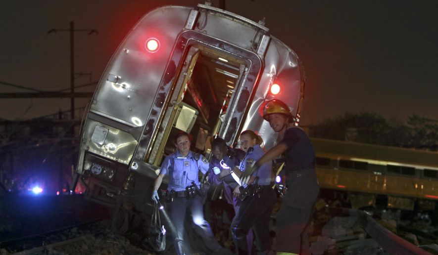 Emergency personnel work the scene of a deadly train wreck, Tuesday, May 12, 2015, in Philadelphia. An Amtrak train headed to New York City derailed and crashed in Philadelphia. (AP Photo/ Joseph Kaczmarek)