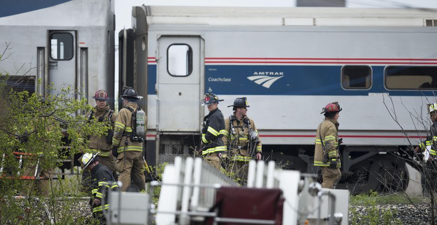 Firefighters get ready to leave the scene where an Amtrak locomotive fire sparked an evacuation of the train, Thursday, May 14, 2015, near the intersection of E. Walker and S. Barclay Sts. in Milwaukee, Wis. Authorities say all passengers and crew members were safely evacuated after a fire broke out in the engine of the Amtrak train in Milwaukee. (Mark Hoffman/Milwaukee Journal-Sentinel via AP)