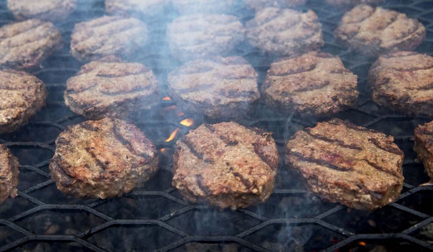 FILE - In this Thursday, July 3, 2014 file photo, smoke wafts up as hamburgers are cooked on a grill outside the White House in Washington. On Thursday, May 14, 2015, the CDC says fewer Americans are getting sick from a nasty germ sometimes found in undercooked hamburgers. Illnesses from a dangerous form of E. coli bacteria have fallen 20 percent in the previous few years. (AP Photo/Jacquelyn Martin)