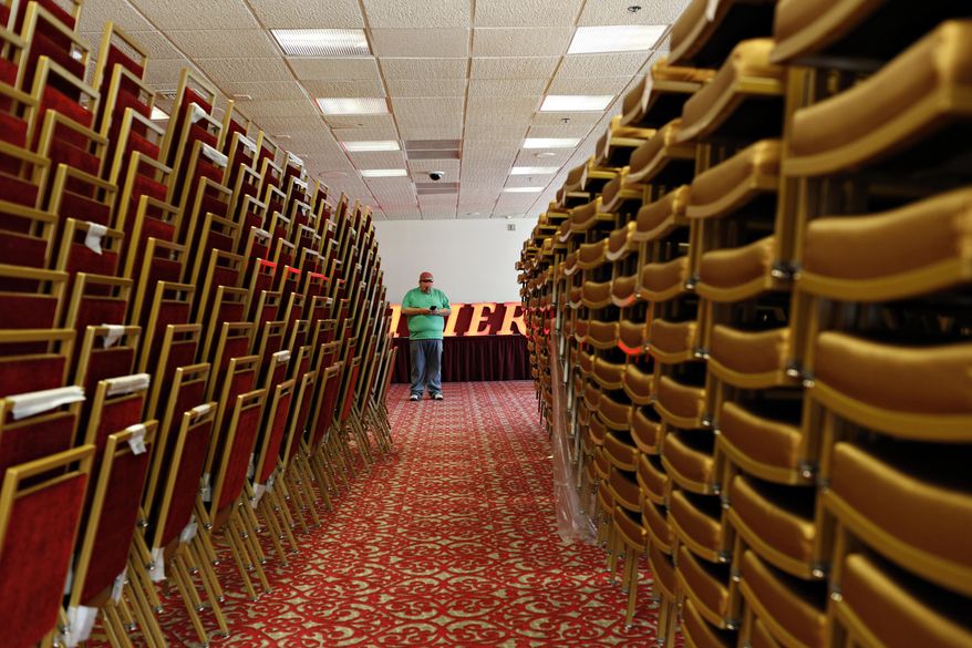 A man looks at his phone among rows of chairs during a liquidation sale at the closed Riviera hotel and casino Wednesday, May 13, 2015, in Las Vegas. The sale will be open to the general public on Thursday. (AP Photo/John Locher)