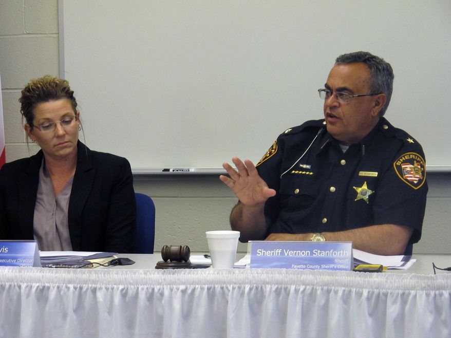 Fayette County Sheriff Vernon Stanforth, right, discusses changes to the way Ohio trains police officers, listened to by Mary Davis, executive director of the Ohio Peace Officer Training Commission, on Thursday, May 14, 2015, in London, Ohio. Stanforth, the commission's chairman, says training adjustments will change law enforcement for generations. (AP Photo/Andrew Welsh-Huggins)