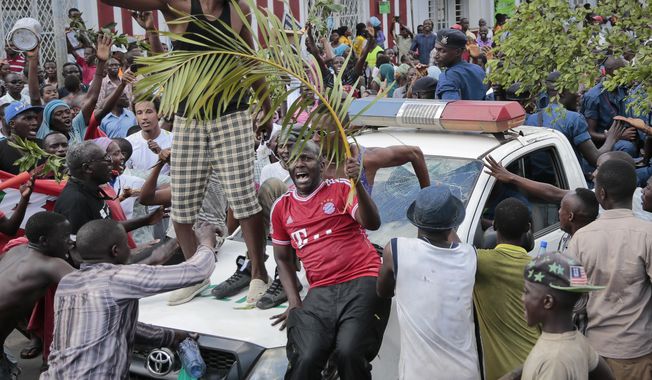 Demonstrators, some holding palm leaves as a peace sign, celebrate what they perceive to be an attempted military coup d&#x27;etat, as they surround a police truck in the capital Bujumbura, Burundi Wednesday, May 13, 2015. Police vanished from the streets of Burundi&#x27;s capital Wednesday as thousands of people celebrated a rumored coup attempt against President Pierre Nkurunziza. (AP Photo/Berthier Mugiraneza)