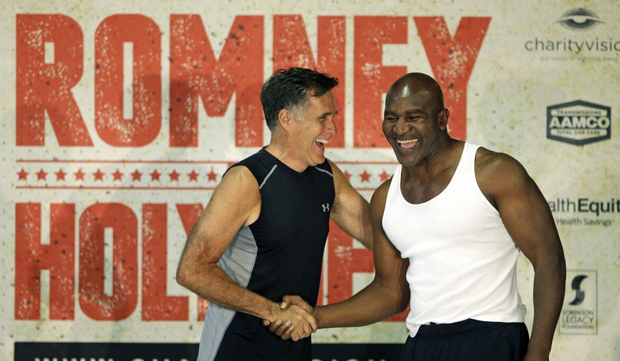 Former Republican presidential candidate Mitt Romney, left, and five-time heavyweight boxing champion Evander Holyfield shake hands after an official weigh-in Thursday, May 14, 2015, in Holladay, Utah. Romney and Holyfield are set to square off at a charity fight on Friday, May 15, in Salt Lake City. (AP Photo/Rick Bowmer)