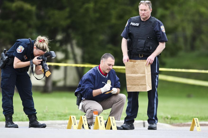 Law enforcement personnel investigate the scene after police shot and killed one man and wounded another following a vehicle chase, Thursday, May 14, 2015, in Portage, Mich. Lt. Dale Hinz of the Michigan State Police, told the Kalamazoo Gazette, the shooting occurred at about 1:10 p.m. in the parking lot of an apartment complex, after a chase began on the east side of Kalamazoo County. The driver pulled into the apartment complex and stopped and one of the men pointed "semi-automatic assault rifle-type weapon," Hinz said. The passenger was killed and the driver was wounded. (Christian Randolph/Kalamazoo Gazette-MLive Media Group via AP) ALL LOCAL TELEVISION OUT; LOCAL TELEVISION INTERNET OUT