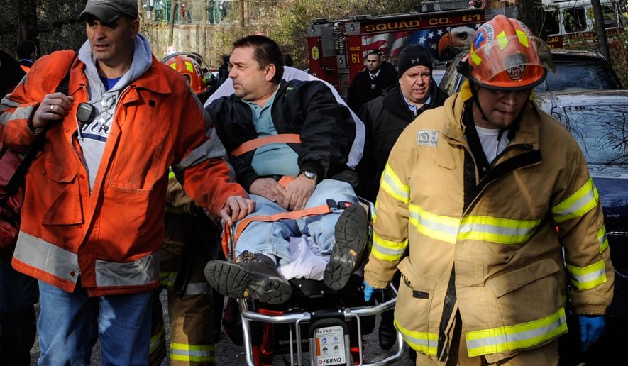 FILE - In this Dec. 1, 2013, file photo, Metro North Railroad engineer William Rockefeller is wheeled on a stretcher away from the area where the commuter train he was operating derailed in the Bronx borough of New York. Prosecutors said on Thursday, May 14, 2015, that Rockefeller, who fell asleep at the controls of a commuter train that derailed and killed four people, will not face criminal charges. (AP Photo/Robert Stolarik, File)