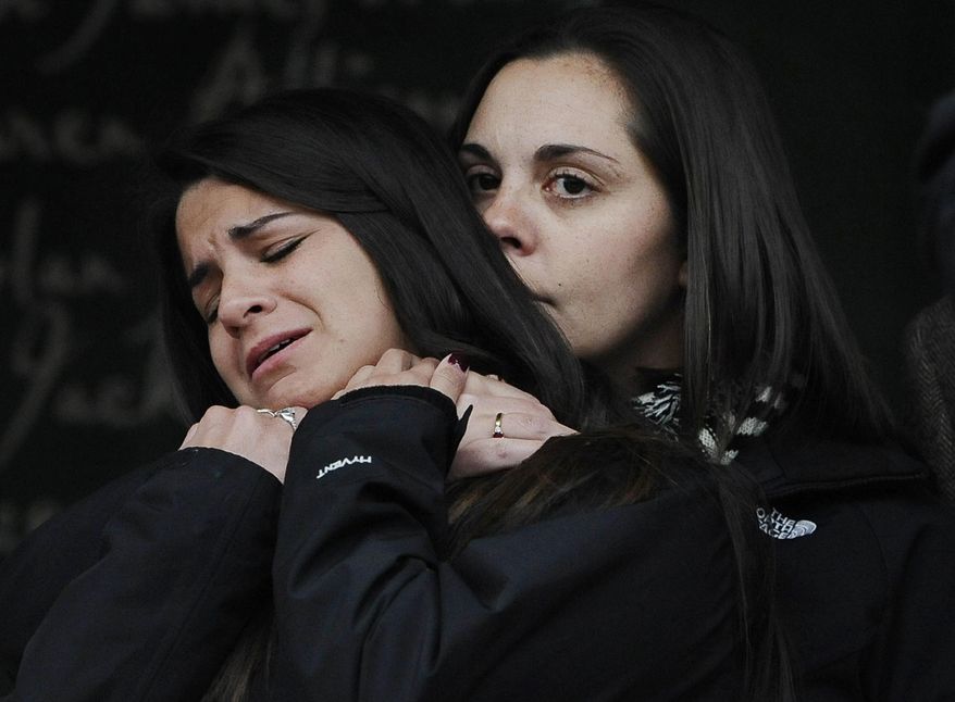 FILE - In this Dec. 9, 2013, file photo, Erica Lafferty, daughter of Sandy Hook Elementary School Principal shooting victim, Dawn Hochsprung, right, consoles Carlee Soto, sister of victim Victoria Soto after families representing fourteen families addressed the media in Newtown, Conn. Esteves School of Education at The Sage Colleges is awarding a doctorate degree posthumously to Hochsprung. Sage Colleges Dean of Education Lori Quigley says Hochsprung’s husband, daughter and other relatives will attend a commencement ceremony on Saturday, May 16, 2015, to receive the degree. (AP Photo/Jessica Hill, File)