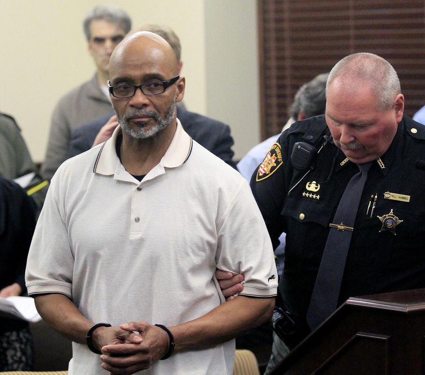 FILE - In this March 20, 2014, file photo, Douglas Prade is taken into custody at the Summit County Courthouse in Akron, Ohio. Prade, a former Akron police captain imprisoned for the fatal shooting of his ex-wife, has dropped a federal lawsuit against investigators who helped convict him. (Karen Schiely, Akron Beacon Journal via AP, File) MANDATORY CREDIT