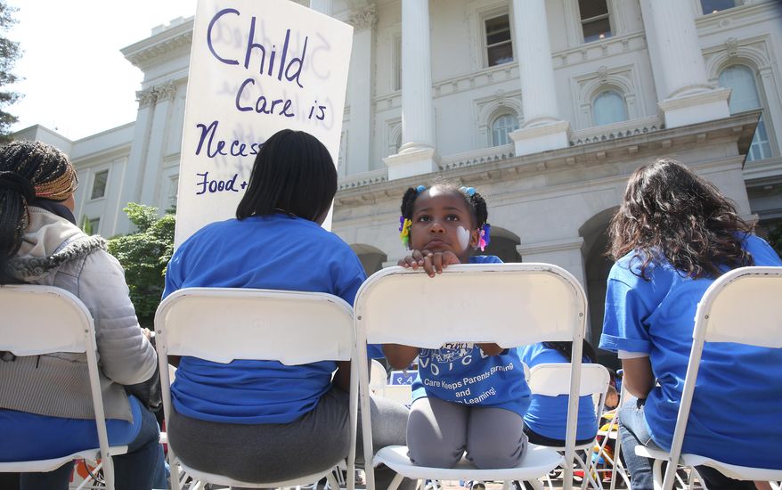 In this photo taken Wednesday May 6, 2015, Saryah Mitchell, 4, sits with her mother, Teisa, Gay, left, a rally calling for increased child care subsidies at the Capitol in Sacramento, Calif. Democratic legislative leaders have made expanding child care for working families a top priority in their budget negotiations with Gov. Jerry Brown.(AP Photo/Rich Pedroncelli)