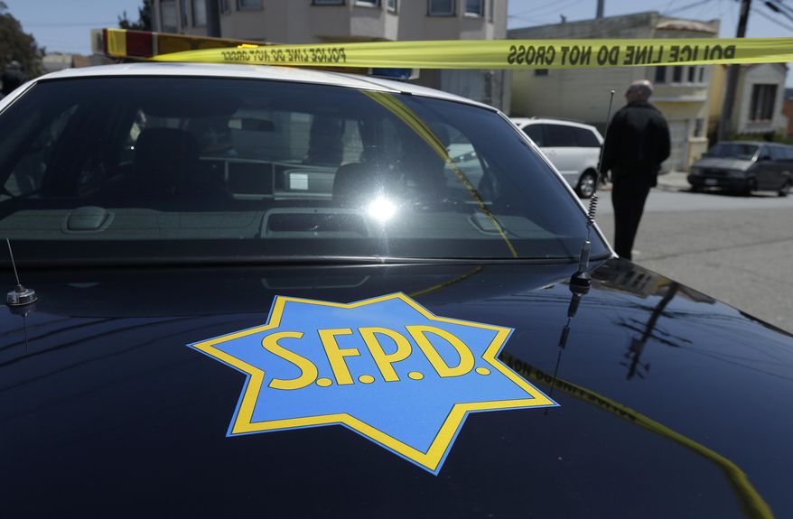 In this May 12, 2015 photo, a San Francisco Police officer walks past a patrol car parked in San Francisco. The original charges were shocking enough: six San Francisco police officers were accused of stealing from suspects living in seedy residential hotels. Then federal prosecutors released racist, homophobic and ethnically insensitive email and text messages exchanged among more than a dozen officers, prompting the San Francisco district attorney to launch a wide-ranging investigation of the police department while considering dismissing up to 3,000 criminal cases involving the officers. (AP Photo/Jeff Chiu)