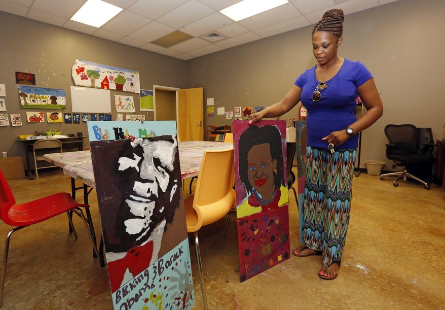 B.B. King Museum and Delta Interpretive Center education coordinator, April Brock, shows off portraits Rosa Parks, Michelle Obama and B.B. King, in Indianola, Miss. that students painted during Black History Month.(AP Photo/Rogelio V. Solis)