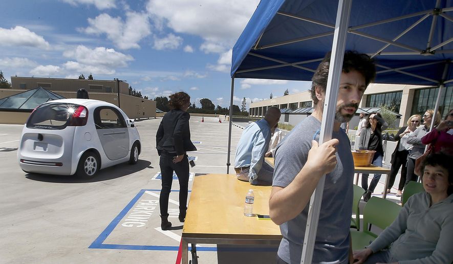 In this May 13, 2015 photo, Google co-founder Sergey Brin, right, speaks to reporters and guests about the new Google self-driving prototype car during a demonstration at the Google campus in Mountain View, Calif. The car, which needs no gas pedal or steering wheel, will make its debut on public roads this summer. (AP Photo/Tony Avelar)