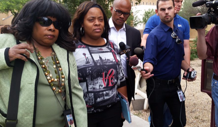 Defense attorney Valeria Llewellyn, left, and Shanesha Taylor leave a downtown Phoenix courthouse surrounded by media on Friday, May 15, 2015. Taylor, who left her two young sons alone in a hot car during a job interview in March 2014, was sentenced to 18 years of supervised probation. (AP Photo/Terry Tang)