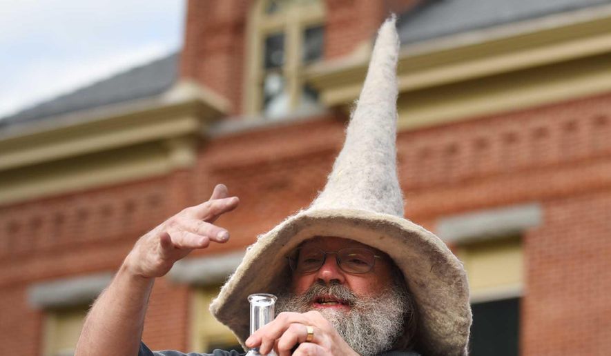 In this photo taken Thursday night, May 7, 2015, retiring University of Montana chemistry professor Garon Smith, aka G. Wiz, entertains the crowd on the UM Oval in Missoula, Mont., with his unique style of education. Smith is hanging up his wizard cloak away after 24 years of teaching. (Michael Gallacher/The Missoulian via AP) MAGS OUT, TV OUT