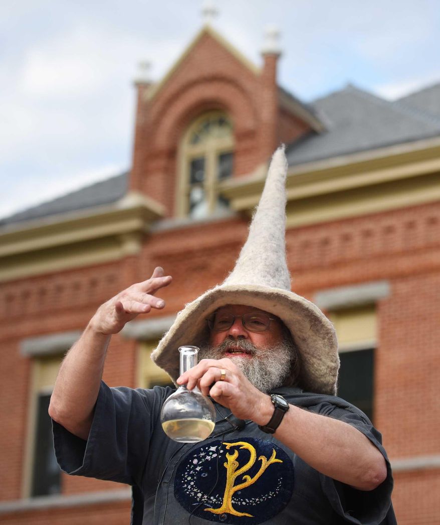 In this photo taken Thursday night, May 7, 2015, retiring University of Montana chemistry professor Garon Smith, aka G. Wiz, entertains the crowd on the UM Oval in Missoula, Mont., with his unique style of education. Smith is hanging up his wizard cloak away after 24 years of teaching. (Michael Gallacher/The Missoulian via AP) MAGS OUT, TV OUT