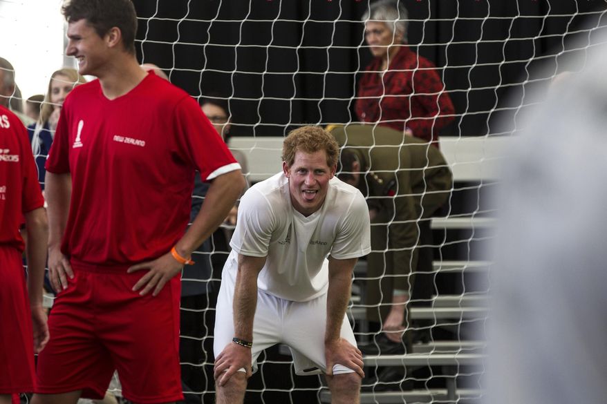 Britain's Prince Harry, center, sticks his tongue out during a 5-a-side football game at The Cloud, a multi-purpose venue in Auckland, New Zealand, Saturday, May 16, 2015. Prince Harry is on the last day of his visit to New Zealand. (Michael Craig/Herald on Sunday via AP) NEW ZEALAND OUT, AUSTRALIA OUT