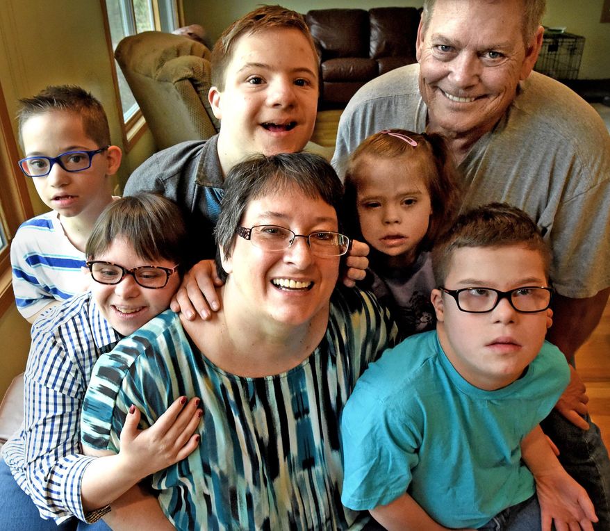 In this photo taken May 2, 2015, Leah Spring, center, poses with her familt at their home in Eagan, Minn. Spring blogs about raising five children with Down syndrome while fighting breast cancer. Surrounding her are, from left: Asher, 10, Angela, 18, Axel 14, Audrey, 10, husband Dean Ellingson and Abel, 12. (Jean Pieri/The St. Paul Pioneer Press via AP) MINNEAPOLIS STAR TRIBUNE OUT