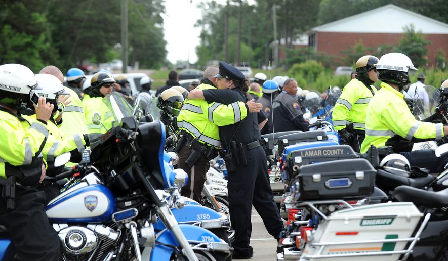 Law enforcement officers, friends and family attend the funeral of Hattiesburg Police Department Officer Liquori Tate at the West Point Baptist Church in Hattiesburg, Miss. on Saturday, May 16, 2015. Tate and Officer Benajmin Deen were killed in the line of duty a week earlier after pulling over a speeding car. (Eli Baylis/The Hattiesburg American via AP)