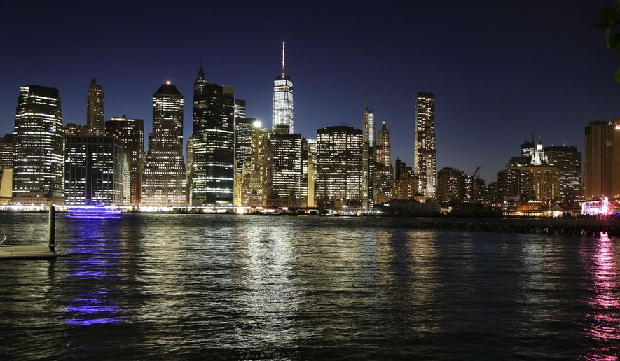 The Manhattan skyline, photographed from Brooklyn Bridge Park, shines in the dusk sky, Thursday, May 14, 2015, in New York. The neon lights of Broadway might not all shine so bright if a push to cut energy usage in the city's buildings comes to pass. Proponents want to see commercial buildings turn off their lights after midnight if the buildings are empty. Critics say it would take away some of what makes New York City sparkle. (AP Photo/Julie Jacobson)