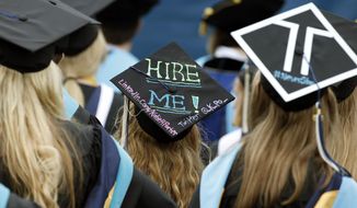 George Washington University graduates, including one looking for a job, are seated during the school&#39;s commencement exercises on the National Mall, Sunday, May 17, 2015 in Washington. (AP Photo/Alex Brandon)  ** FILE **