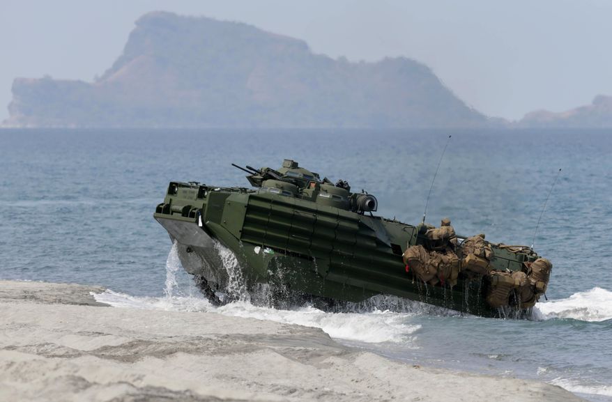 FILE - In this April 21, 2015 file photo, an amphibious assault vehicle with Philippine and U.S. troops on board storms a beach during an annual U.S.-Philippines joint military drill at the Naval Education and Training Command at San Antonio township, Zambales province, northwest of Manila, Philippines. Amphibious military capabilities are on the agenda the week of May 18, 2015, as the U.S. Marine Corps and Navy host defense leaders from around the Pacific in Hawaii. (AP Photo/Bullit Marquez, File)