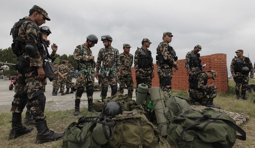 FILE - In this Friday, May 15, 2015, file photo, Nepalese army soldiers prepare to leave for a rescue mission to the site where the suspected wreckage of a U.S. Marine helicopter, that disappeared earlier this week while on a relief mission in the earthquake-hit Himalayan nation, was spotted, in Kathmandu, Nepal. Nepalese rescuers on Friday found three bodies near the wreckage of the chopper that was carrying six Marines and two Nepalese army soldiers. (AP Photo/Niranjan Shrestha, File)