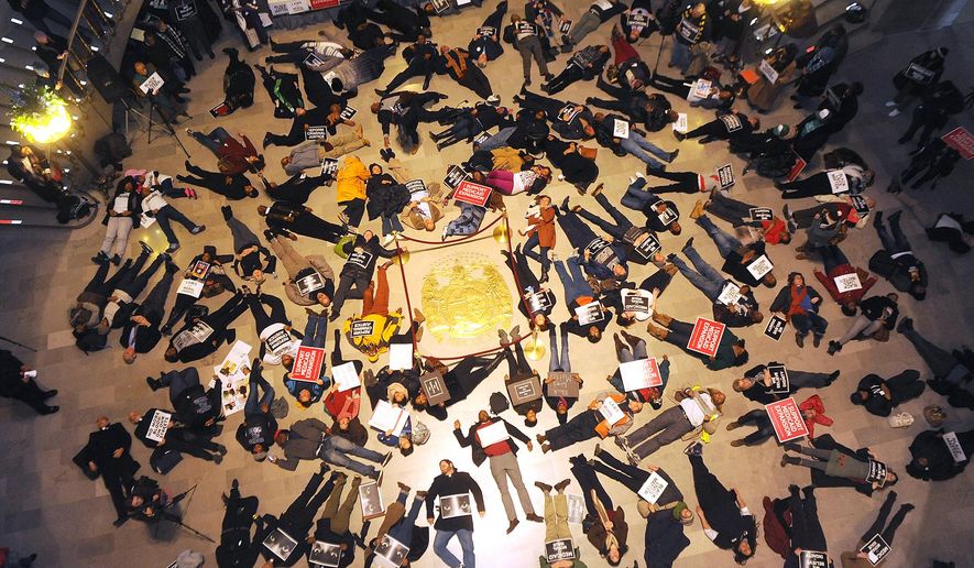 FILE - In a Wednesday Jan. 7, 2015 file photo, about 130 people stage a die-in on the floor of the Missouri State Capitol Rotunda shortly before the 98th Missouri General Assembly begins to protest the Ferguson shooting of Michael Brown. Missouri’s Legislature ended with little action on bills proposed in response to the fatal shooting of Michael Brown by a Ferguson police officer. On Friday, May 15, 2015, partisan discord sent the Senate home early without taking action on a measure that would have limited police use of deadly force. (Don Shrubshell/Columbia Daily Tribune via AP, File)