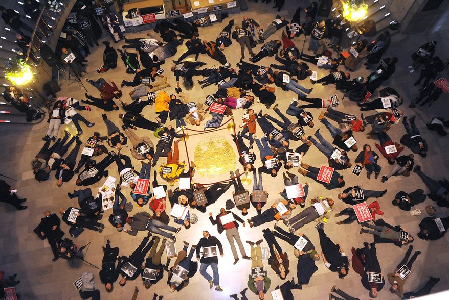 FILE - In a Wednesday Jan. 7, 2015 file photo, about 130 people stage a die-in on the floor of the Missouri State Capitol Rotunda shortly before the 98th Missouri General Assembly begins to protest the Ferguson shooting of Michael Brown. Missouri’s Legislature ended with little action on bills proposed in response to the fatal shooting of Michael Brown by a Ferguson police officer. On Friday, May 15, 2015, partisan discord sent the Senate home early without taking action on a measure that would have limited police use of deadly force. (Don Shrubshell/Columbia Daily Tribune via AP, File)