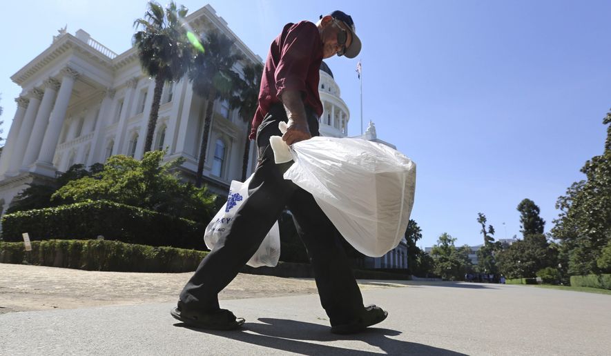 In this Aug. 12, 2014 file photo, a man carries plastic single-use bags past the State Capitol in Sacramento, Calif. Election officials said Monday, Feb. 23, 201 that a trade group had turned in enough signatures to qualify a referendum on California’s plastic bag ban law, suspending implementation of the nation’s first statewide ban until voters weigh in on the November 2016 ballot. In many cases, states have stepped in after city officials somewhere in the nation proposed local policies that business leaders didn’t like. Businesses have warned lawmakers that a potential patchwork of local regulations could be bad for the economy. (AP Photo/Rich Pedroncelli, File)