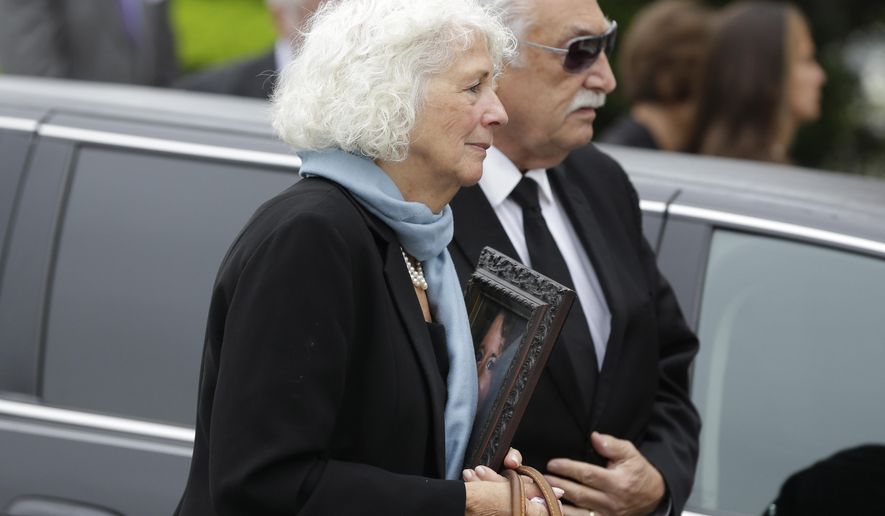 A family member carries a picture of Laura Finamore, who was killed in the May 12 Amtrak train derailment in Philadelphia, into the church during her funeral in New York, Monday, May 18, 2015. Finamore, 47, was returning to New York City from a memorial service for a college friend's mother. (AP Photo/Seth Wenig)