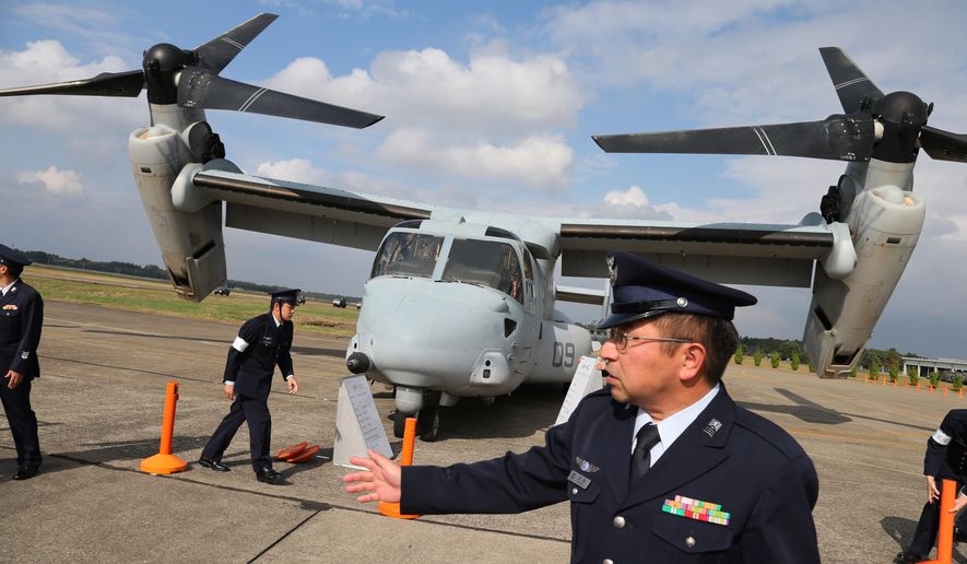 FILE - In this Oct. 26, 2014 file photo, Japan Self-Defense Forces personnel stand guard an MV-22 Osprey during the annual Self-Defense Forces Commencement of Air Review at Hyakuri Air Base, north of Tokyo. A fatal crash of a U.S. Marine Corps aircraft in Hawaii has renewed safety concerns in Japan, where more of the Ospreys will be deployed. A tilt-rotor MV-22 Osprey caught fire after a hard landing on Sunday, May 17, 2015, killing one Marine and injuring 21 others at Bellows Air Force Station on Hawaii’s main island of Oahu. (AP Photo/Eugene Hoshiko, File)