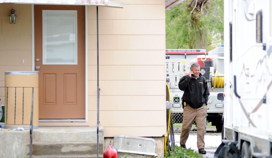 Billings Police Department Lt. Jeremy House walks past the house where a 15-year-old boy was shot and killed earlier in the morning, Sunday, May 17, 2015. A Montana boy startled at being awakened in the middle of the night fired a shot through his bedroom window and killed the 15-year-old friend who had been knocking and throwing pebbles at his window, police said Monday. (Hannah Potes/The Billings Gazette via AP)
