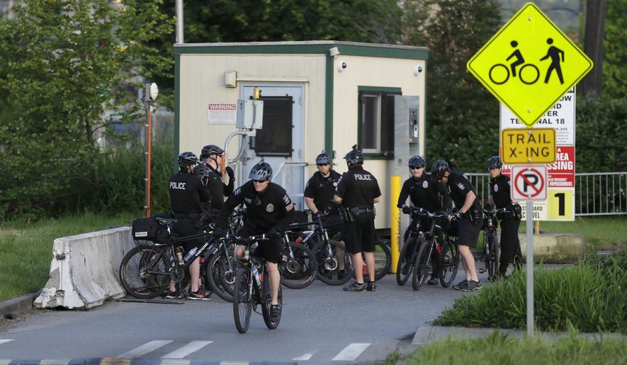 Police on bicycles gather at an entrance to a Port of Seattle facility, Monday, May 18, 2015, in Seattle, near the site where a protest against Arctic oil drilling was planned for later in the morning. Demonstrators have been showing opposition to a lease agreement between Royal Dutch Shell and the Port of Seattle to allow Shell's oil drilling equipment to be based in Seattle. (AP Photo/Ted S. Warren)