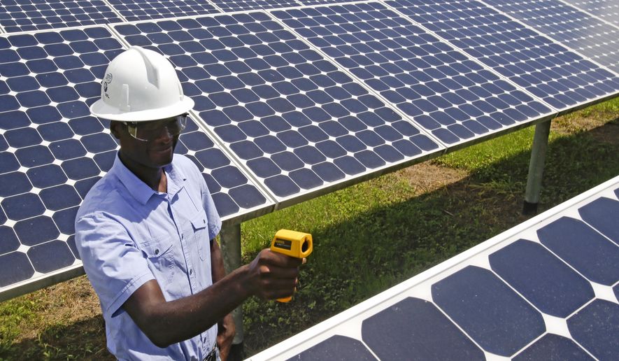 In this Wednesday, May 13, 2015 photo, Henry Plange, a power generation engineer, checks temperatures of solar panels at the Space Coast Next Generation Solar Center, in Merritt Island, Fla. Industry experts rank Florida third in the nation in rooftop solar energy potential but 13th in the amount of solar energy generated. (AP Photo/John Raoux)