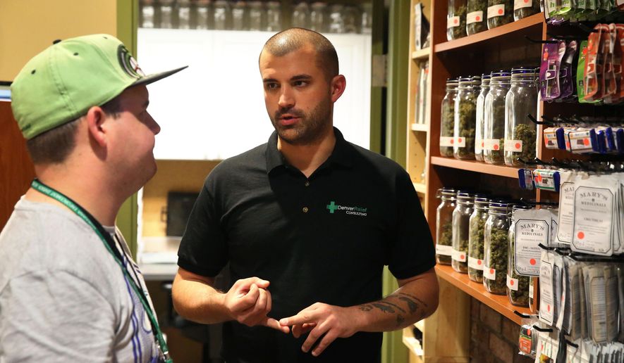 FILE - In this Aug. 25, 2014 photo, marijuana store Denver Relief co-owner Kayvan Khalatbari, right, talks with his employee Jeff Botkin at his medical and recreational marijuana shop in Denver. A new lawsuit has been filed involving Illinois medical marijuana, this one claiming Khalatbari schemed to monopolize the state’s new industry. Medponics Illinois filed the lawsuit Monday, May 18, 2015, in Lake County. It claims Khalatbari and his Denver Relief Consulting companies have controlling interests in more than three cultivation center companies in violation of Illinois rules.(AP Photo/Brennan Linsley, File)