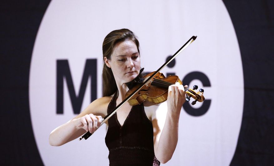 Rebekah Butler, whose stage name is "Becka Jay," plays solo violin as she auditions for judges in Grand Central Terminal's Vanderbilt Hall in New York, Tuesday, May 19, 2015. Butler was among a group of about 70 potential subway performers seeking official permission to set up their acts on an underground platform or walkway to entertain New York city's commuters. (AP Photo/Kathy Willens)