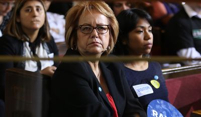 Maria Elena Durazo, an official at the national labor organization Unite Here and former head of the Los Angeles County Federation of Labor, center, and Ilse Escobar, program director at the Miguel Contreras Foundation, listen to motions as the Los Angeles City Council votes to raise the minimum wage in the city to $15 an hour by 2020, making it the largest city in the nation to do so, in Los Angeles Tuesday, May 19, 2015. The measure approved Tuesday calls for small businesses with 25 or fewer employees to have an additional year to reach the $15 plateau. The council voted 14-1 after members of the public made impassioned statements for and against the plan. The increases begin with a wage of $10.50 in July 2016, followed by annual increases to $12, $13.25, $14.25 and then $15. Small businesses and nonprofits would be a year behind. (AP Photo/Damian Dovarganes )