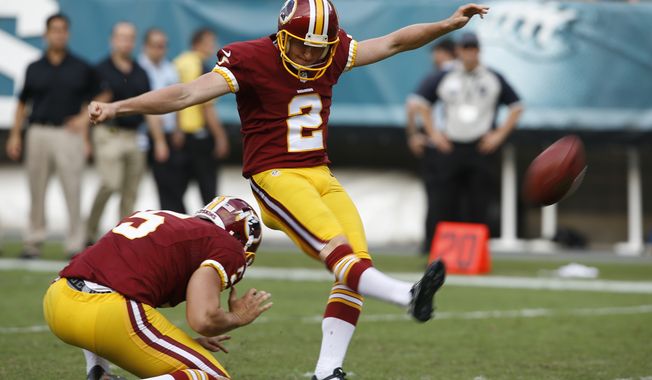 Washington Redskins kicker Kai Forbath, right, with Tress Way holding, kicks an extra point against the Philadelphia Eagles during the second half of an NFL football game Sept. 21, 2014 in Philadelphia. (Associated Press)