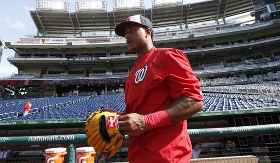 Washington Nationals shortstop Wilmer Difo (1) puts on his glove for batting practice before an interleague baseball game against the New York Yankees at Nationals Park, Tuesday, May 19, 2015, in Washington. (AP Photo/Alex Brandon)