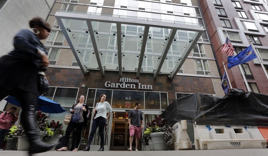 People leave the Hilton Garden Inn, in New York, Monday, May 18, 2015. New York City police are investigating the death of a man found unconscious, with a head injury, under a mattress at the hotel, blocks from the Empire State Building. (AP Photo/Richard Drew)