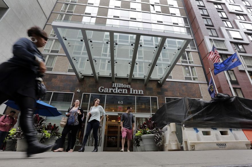People leave the Hilton Garden Inn, in New York, Monday, May 18, 2015. New York City police are investigating the death of a man found unconscious, with a head injury, under a mattress at the hotel, blocks from the Empire State Building. (AP Photo/Richard Drew)